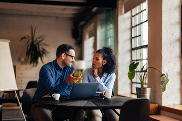 People having a conversation, working together, over the laptop.