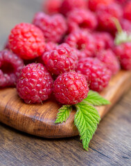 Close up of fresh ripe raspberries on wooden board