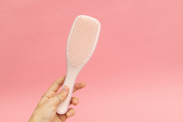 Plastic hairbrush with pink background