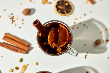 Cup with Christmas mulled red wine with spices and oranges on a white background hard light, traditional hot drink at Christmas, festive cocktail