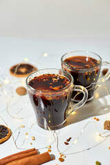 Cup with Christmas mulled red wine with spices and oranges on a white background hard light, traditional hot drink at Christmas, festive cocktail