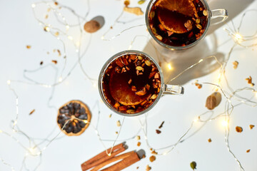 Cup with Christmas mulled red wine with spices and oranges on a white background hard light,...