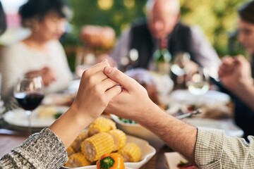 Party, food and family holding hands for prayer before eating chicken, barbecue or turkey at a...