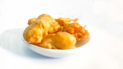 Indonesian style fried banana in a small bowl on a white background, traditional snacks