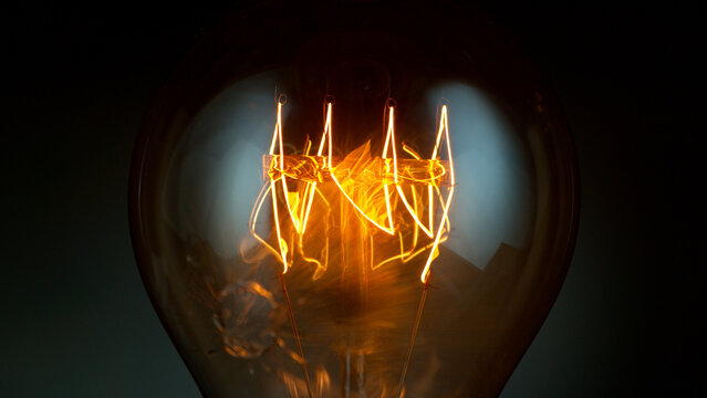 Close-up of shining vintage light bulb, dark background