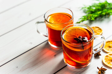 Zwei Gläser Glühwein mit Gewürzen auf einem weißen Holztisch. Weihnachten.