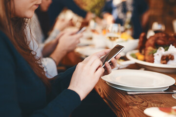 Closeup, woman and phone chatting at dinner on social media, web or app for communication at party. Girl, smartphone and internet at table, lunch or celebration in restaurant, home or thanksgiving