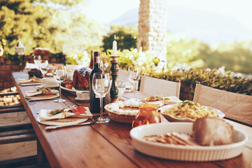 Food, wine and celebration lunch or dinner for Christmas holiday at outdoor dining table for party or event. Healthy eating, alcohol and nutrition for patio or backyard thanksgiving party background