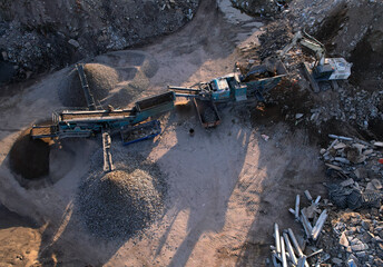 Recycling concrete and asphalt from demolition. Excavator at landfill the load concrete waste in a...