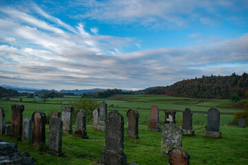 Gothic cemetery in Argyll Scotland sunrise. old graveyard early morning blue sky few clouds