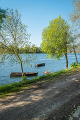 Boats in Lima River. Park bench in river side view in nature landscape, Ponte de Lima, Portugal