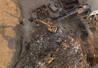 Landfill with Construction waste (CDW). Trash disposal for recycling and re-use. Excavator log grab...