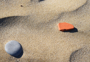 Stones on sand at beach. Sea stones background at seashore. Colored stone on coastline. Stone on sand background at sea beach. Pebbles at coast. Pebble as abstract natural background. Sea stones. .