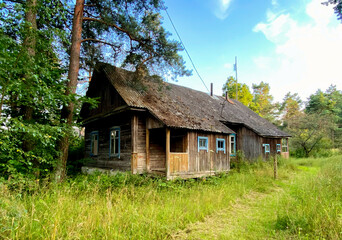 Fototapeta na wymiar Old wooden house in the country in the garden. Home in rural area. Traditional exterior in soviet. Countryside russian design. Abandoned building in village in the autumn season. Soft focus.