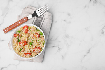 Delicious quinoa salad with tomatoes, beans and parsley on white marble table, top view. Space for text