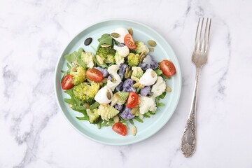 Delicious salad with cauliflower, tomato and cheese served on white marble table, flat lay
