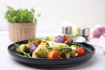 Delicious salad with cauliflower and tomato served on white table, closeup