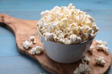Tasty popcorn on light blue wooden table, closeup