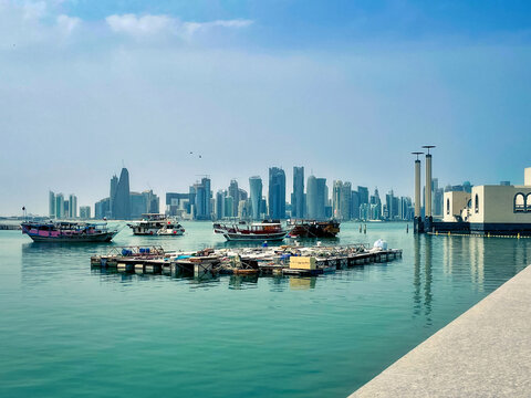 Doha, Qatar -Apr 13, 2022: View from the shore next to the Museum of Islamic Art, daytime, in Doha, Qatar. Perspective view on the waterfront with the city skyline in the background.