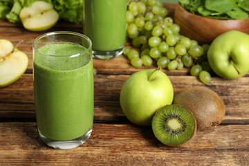 Green smoothie and fresh ingredients on wooden table