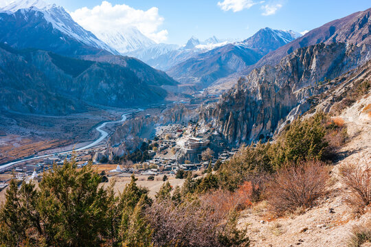 Stunning open landscape with no people in the mountains of the Anapurna Circuit in Nepal. Snowy mountains and blue sky. View of the Manang Valley