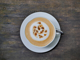 Cappuccino coffee in a white cup on the table