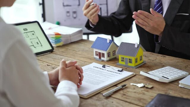Real estate agent talked about the terms of the home purchase agreement and asked the customer to sign the documents to make the contract legally, Home sales and home insurance concept.