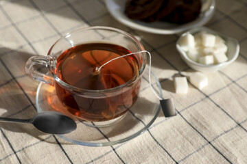 Tea bag in glass cup on table, closeup