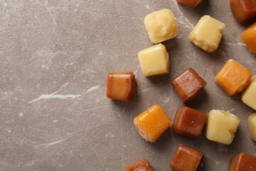 Different frozen fruit puree cubes on brown marble table, flat lay. Space for text