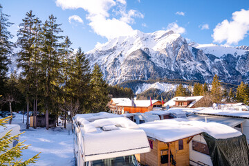 Camping im Winter im Schnee. Reisemobil und Wohnwagen im Winter zum Campen in den Bergen. Schnee und Eis in der Schweiz