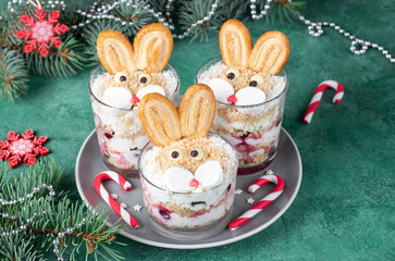 New Year's dessert in glasses the form of cute rabbits with cherries, cookies and curd cream. Symbol of the new year 2023