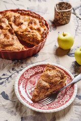 Classic American apple pie on linen tablecloth. Homemade american autumn dessert: sliced apple pie (tart) with cinnamon. Selective focus - 548730115