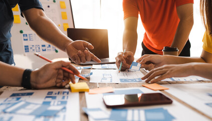 Working at desk, start up, UX team works from a single location under a UX leader and UX managers,...