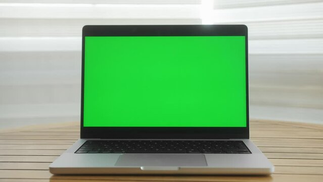 Green screen laptop computer close up. Modern chroma key green screen laptop computer set up for work on desk.
