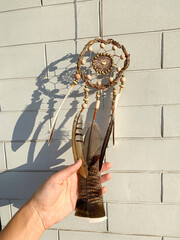 Close up pheasant feathers dream catcher bohemian wall hanging craft outdoors