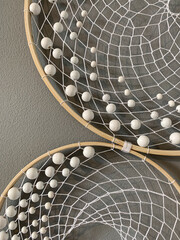 Close-up white feathers dreamcatcher craft on gray background