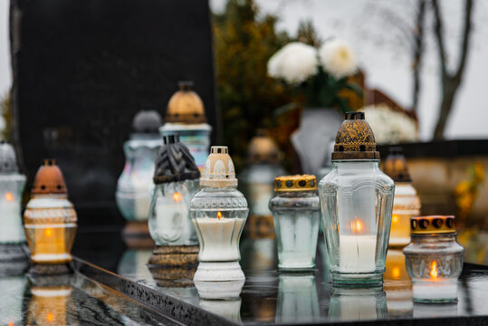 All Saints' Day and burning candles and flowers on the graves.Candles on graves symbolize the memory of the dead on November 1.Catholic cemetery during All Saints' Day.Selective focus.