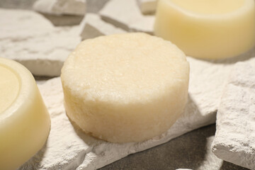 Solid shampoo bars on light grey table, closeup