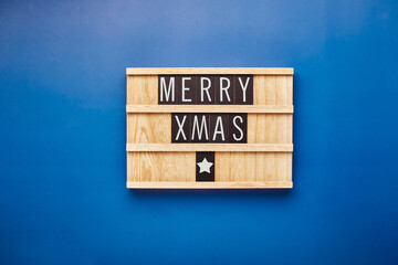 Letter board with text Merry Xmas on blue background. Holiday card, Christmas greetings concept. Flatlay.