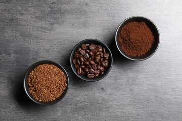 Bowls of beans, instant and ground coffee on grey table, flat lay