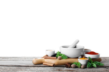 Mortar and different spices on wooden table against white background. Space for text