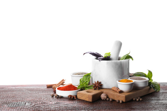 Mortar and different spices on wooden table against white background. Space for text