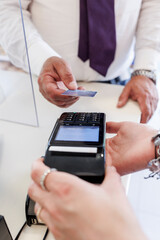 Dettaglio del pagamento con carta di credito da parte di un cliente alla cassa di un negozio.