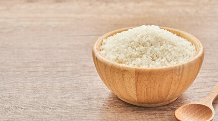 heap of short grain rice in wood bowl on wooden table background                                                            