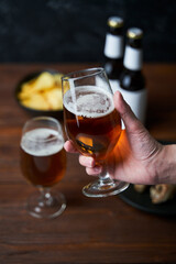 Two glasses with beer, snacks and bottles