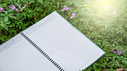 White notebook paper on the grass with copy space                              