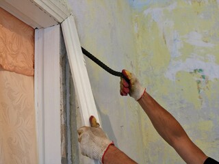 breaking out with a crowbar a wooden door jamb painted with white paint by the hands of a repairman...