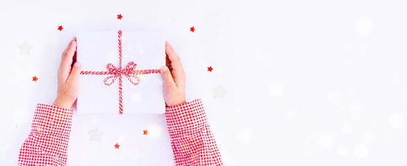 banner gift box in children's hands on a white background, presenting a gift