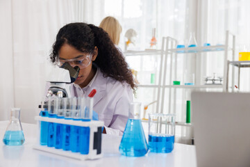 close up, Young woman scientist looking through a microscope in a chemical laboratory. medical science looking at sample on the glass plate. oil and energy research  development concept.