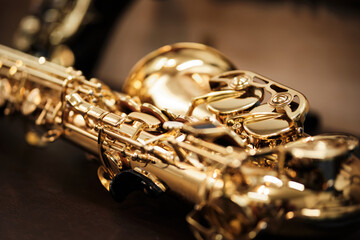 close-up of a golden tenor saxophone on a table - obrazy, fototapety, plakaty